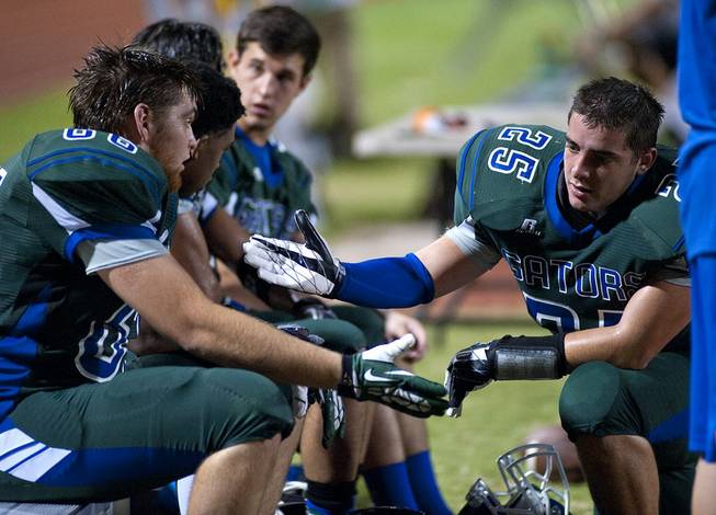 Linebacker Nicholas Perez, right, looks to lift the spirits of defensive end Preston Quirt on the bench as the Green Valley Gators find themselves trailing the visiting Basha Bears 27-3 after a first half riddled with mistakes draws to a close on Friday night at Green Valley High School.
